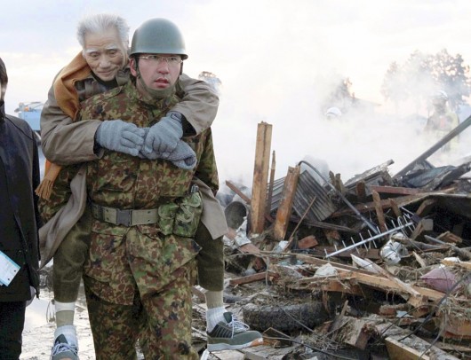 Солдат Сил Самообороны Японии помогает пожилому мужчине в Натори, Префектура Мияги 12 марта 2011 (Фото - REUTERS Yomiuri)